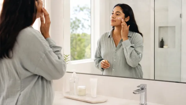 Expectant mother applying sunscreen beside a simple pregnancy-safe skincare routine